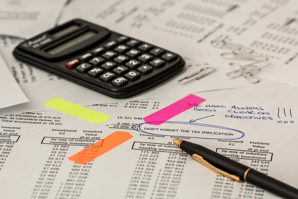 Calculator on printed statements marked with sticky tabs