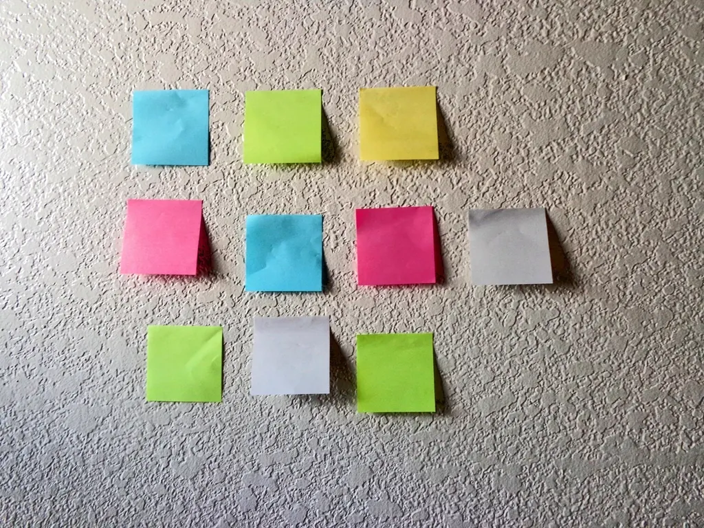 Colored sticky notes arranged in a grid on a wall