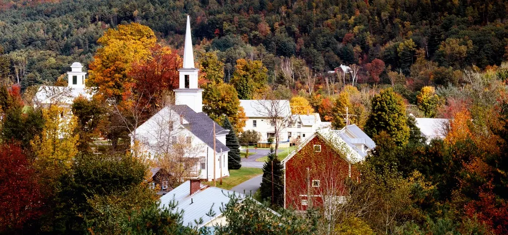 A New England village with a white church in autumn colour