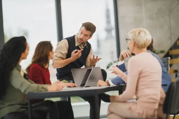 Consultant leading a discussion with colleagues at an office table