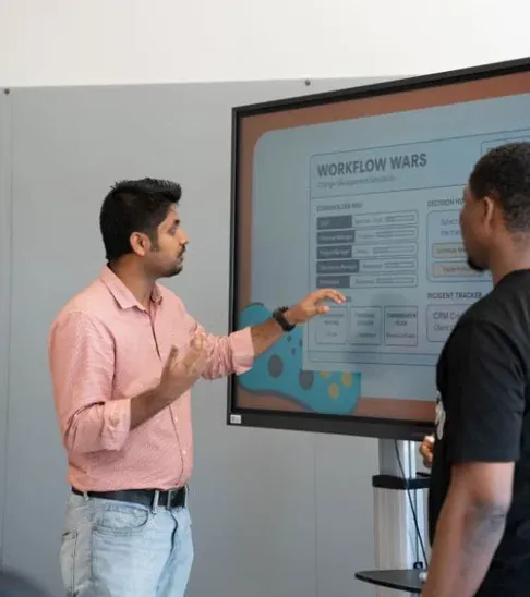 Consultant presenting a rollout plan on a screen to a colleague