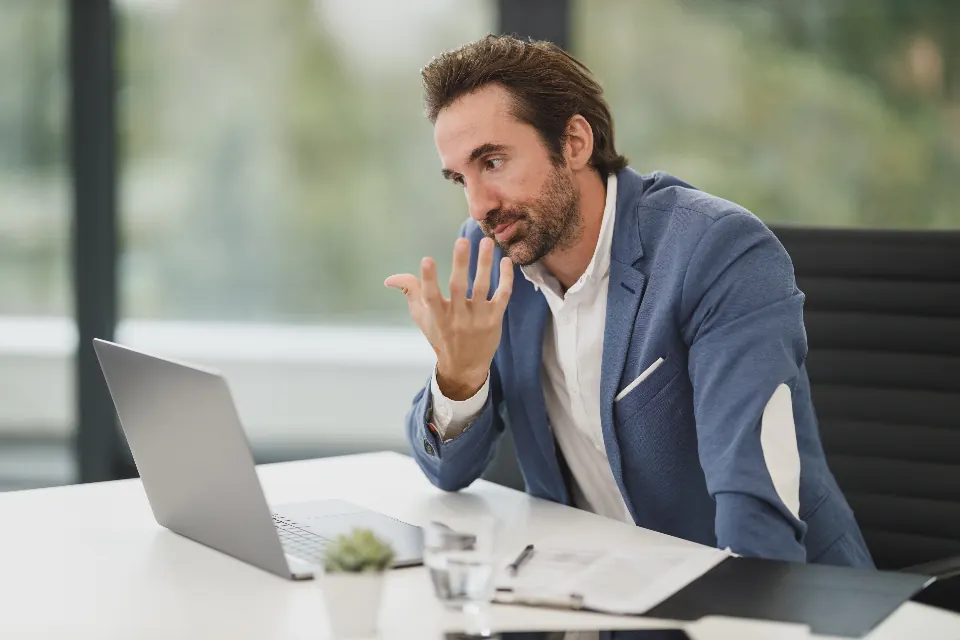Consultant thinking through a problem at a laptop in an office