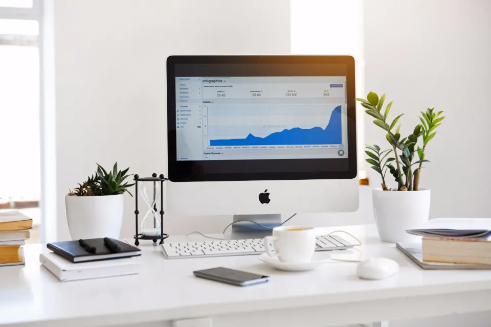 Desktop monitor showing charts on a white desk