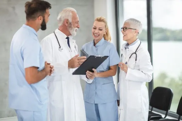 Doctors and nurses discussing notes on a clipboard