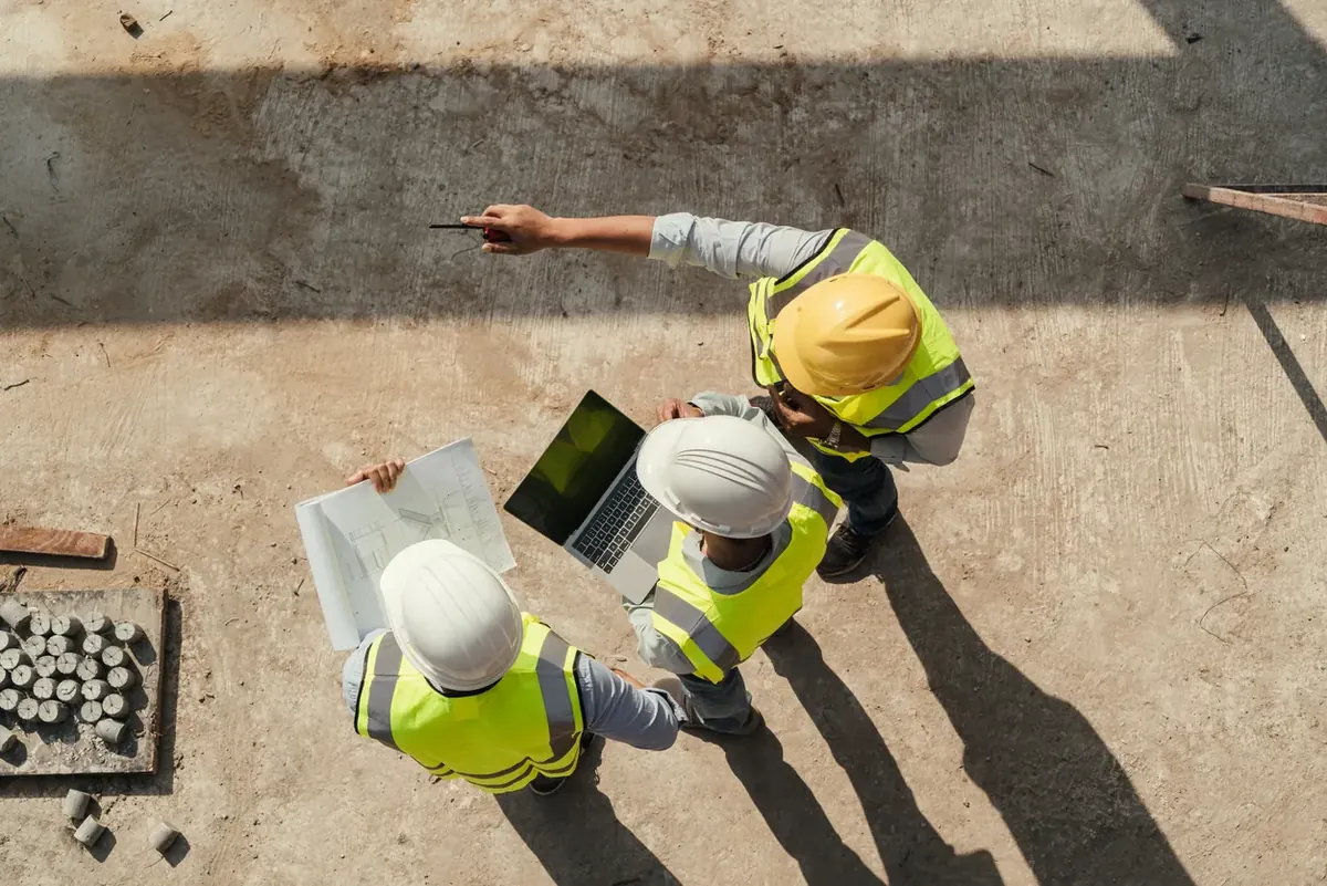 Field technicians in hard hats working together on a job site