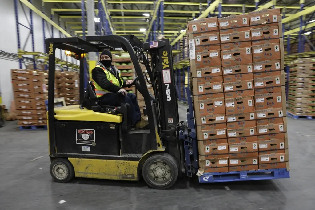 Forklift moving pallets down a distribution center aisle