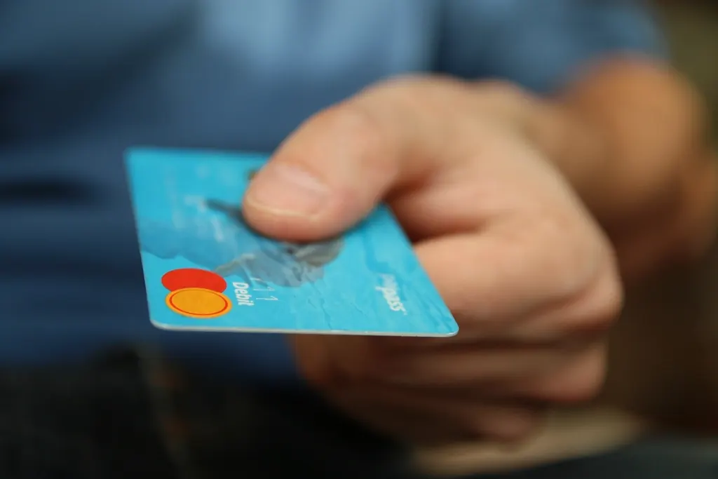 Hand holding out a credit card to pay