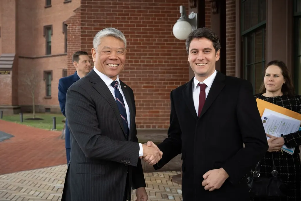 Two business people shaking hands across a meeting table