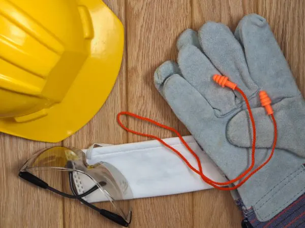 Hard hat, work gloves and safety glasses on a table
