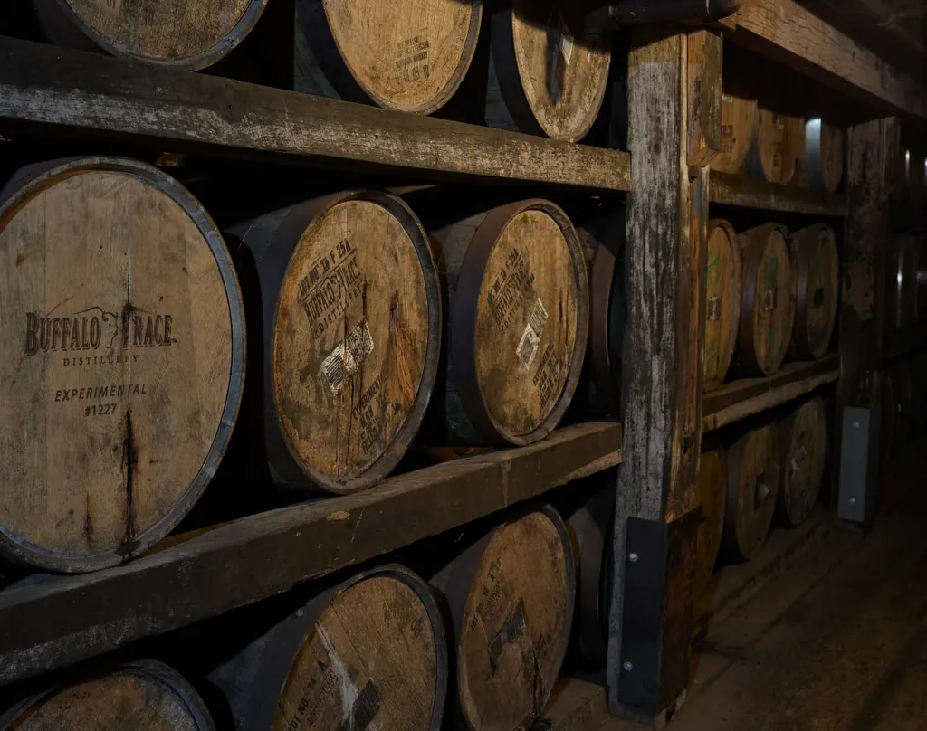 Rows of bourbon barrels stacked inside a Kentucky rickhouse