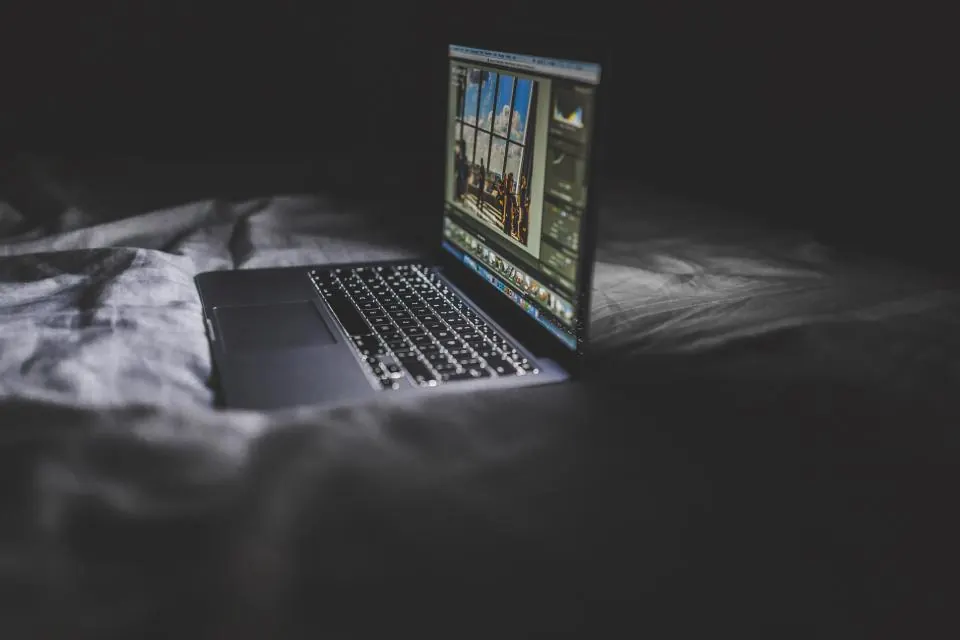 Open laptop glowing in a dark room