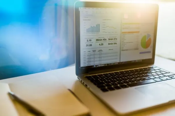 Laptop showing charts and tables on an office desk