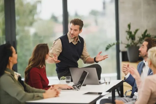 Man explaining a plan to seated colleagues