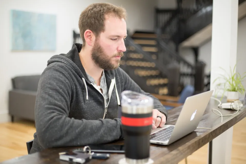 Man reading his laptop screen at a desk