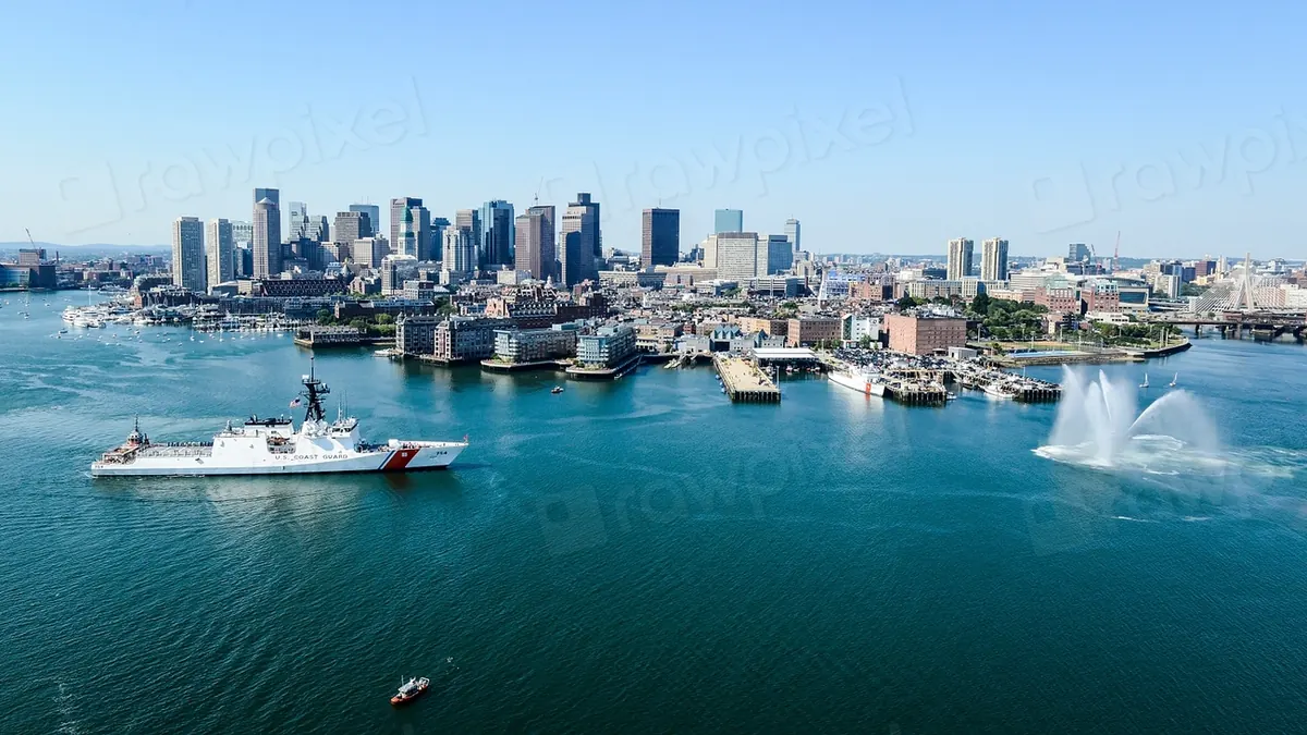Boats on Boston Harbor with the Massachusetts skyline behind