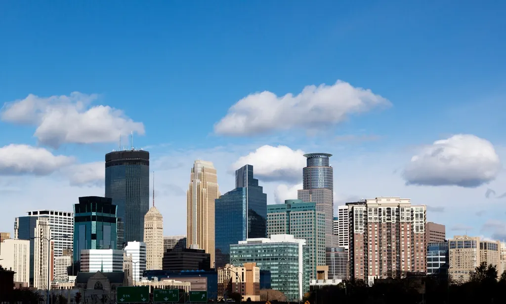 Downtown Minneapolis skyline under a blue sky with clouds
