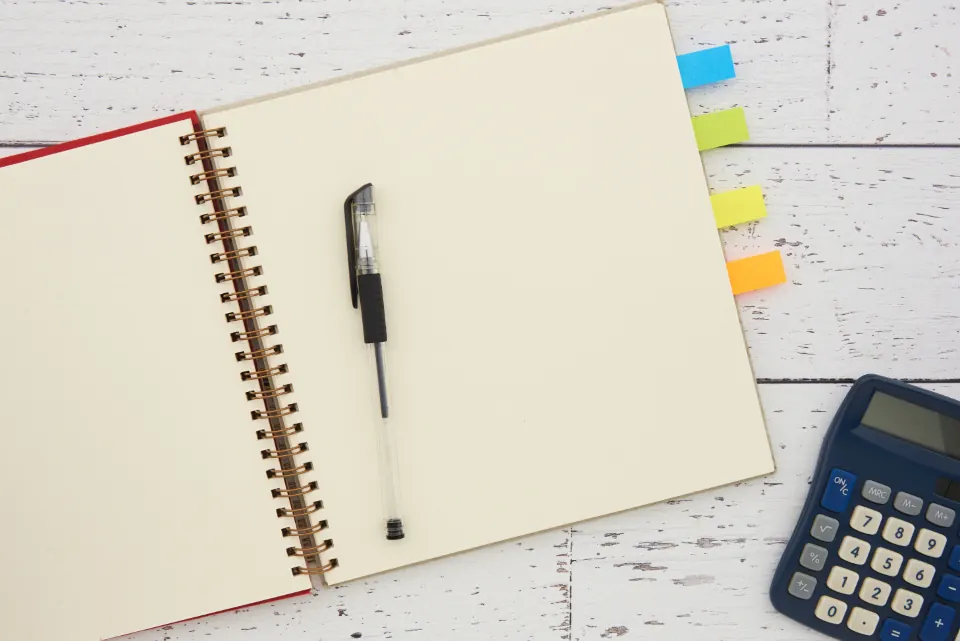 Open notebook, pen and calculator ready on a desk
