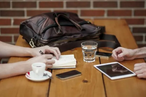 Notebook, tablet and bag on a wooden table