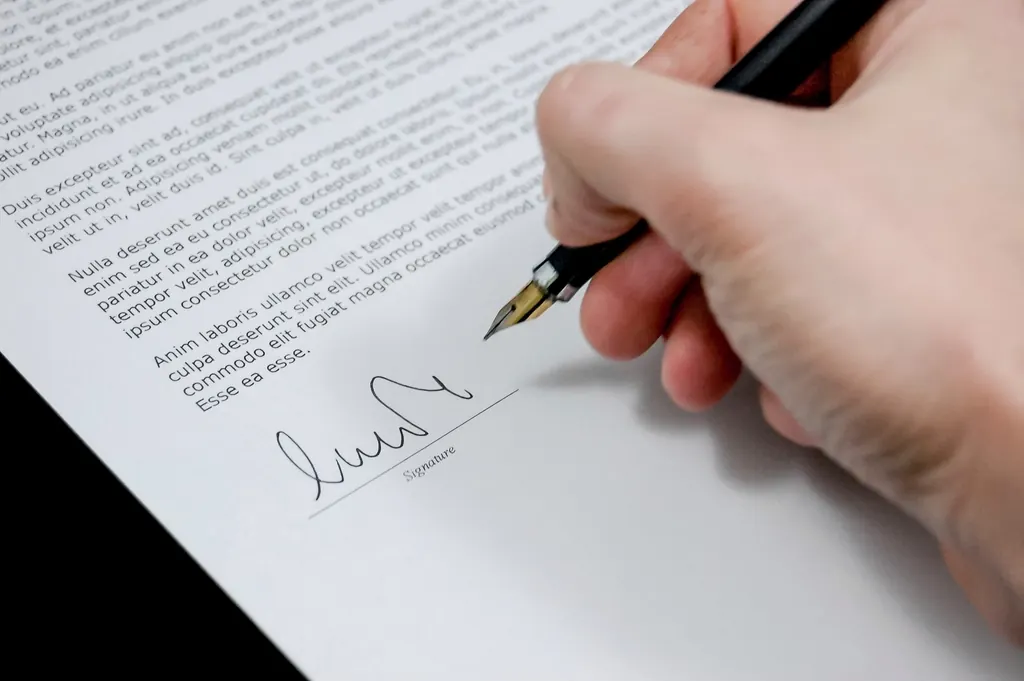 Ballpoint pen lying on printed agreement pages on a desk
