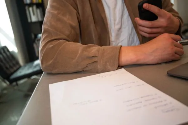 Person reviewing handwritten papers at a table