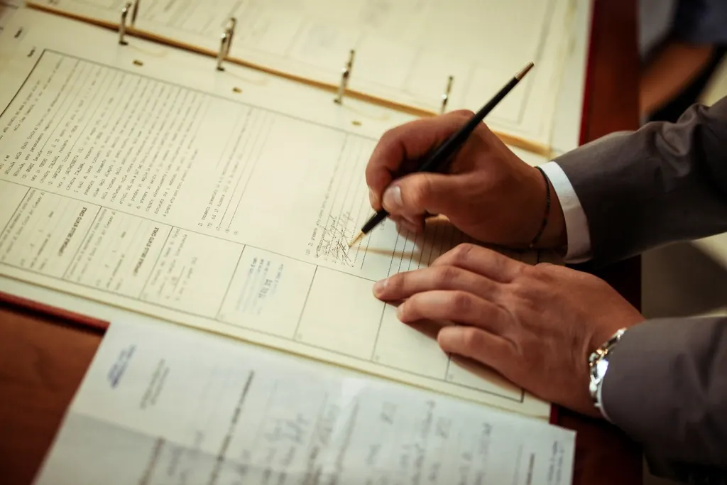 Person signing papers held in a ring binder