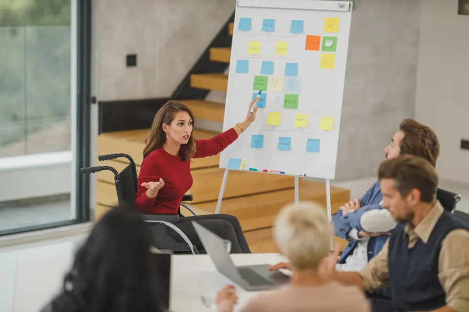 Presenter at a sticky note board walking a team through a plan
