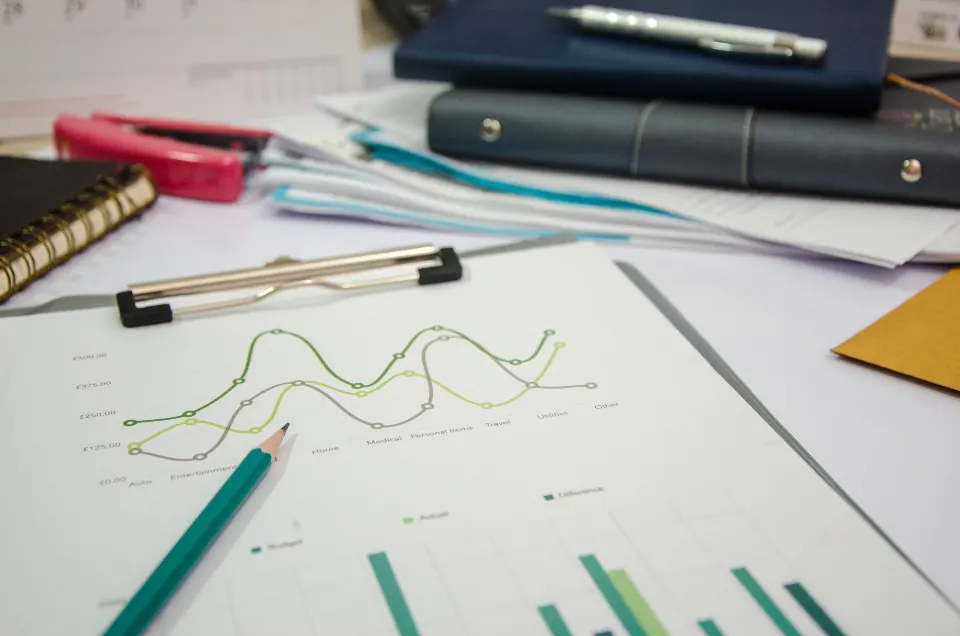 Printed line and bar charts with pens on a desk
