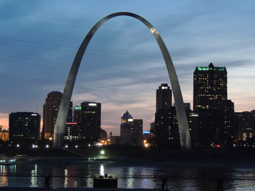 Gateway Arch beside the downtown St. Louis skyline at dusk