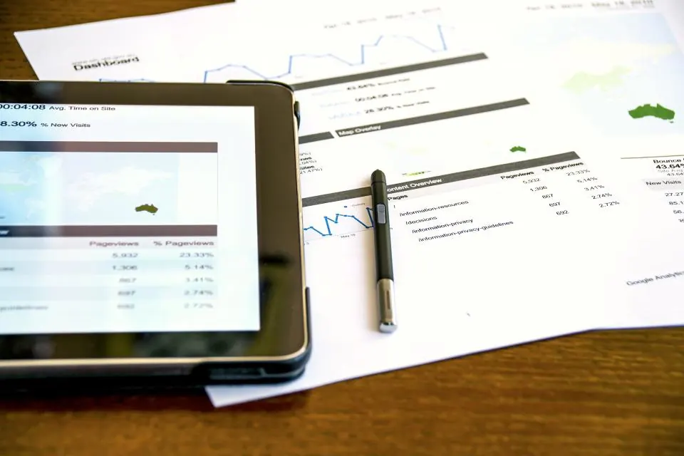 Tablet and printed data reports laid out on a desk