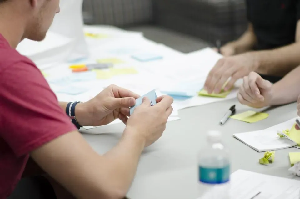 Team members planning a project with sticky notes on a table