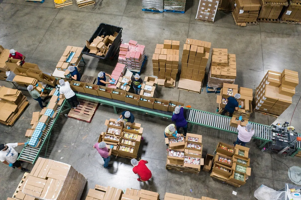 Warehouse packing floor with cartons and conveyors from above