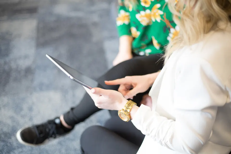 Woman tapping a tablet screen while seated